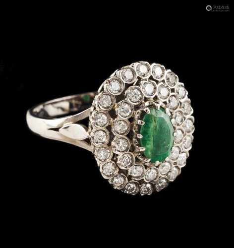 A ringGoldSet with oval cut emerald (ca.7x5mm) framed by two brilliant cut diamond friezes