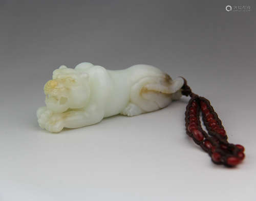 A CHINESE CARVED HETIAN JADE TIGER ORNAMENT