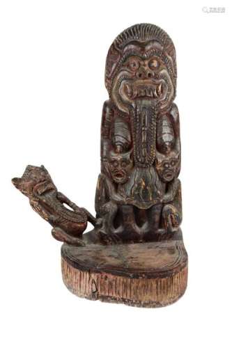 A BALINESE CARVED WOOD SCULPTURE OF RANGDA WITH AT…