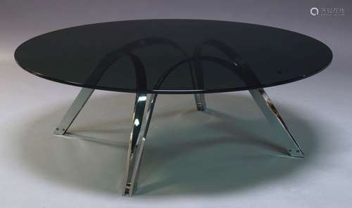 A modern chrome coffee table, c.1980, with circular tinted glass top, on curved chrome supports,