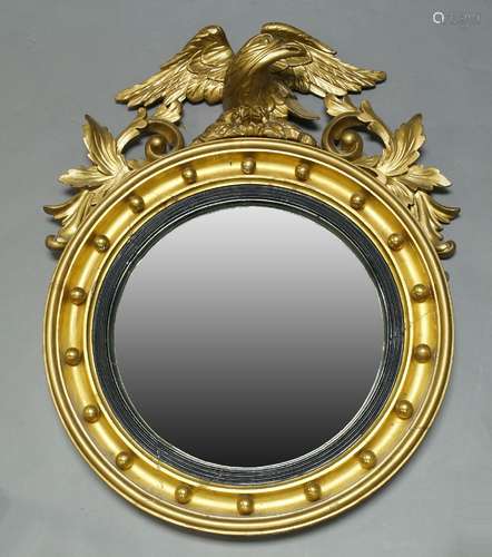 A giltwood wall mirror, 19th Century and later, with later carved eagle and scrolling foliate crest,