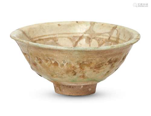 An Iranian bowl, covered with a greenish white glaze, decorated with a band of geometrical