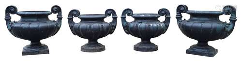 A set of four Victorian cast iron painted garden urns, with twin handles and lobed bodies on round