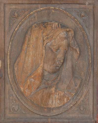 An Italian pressed wood plaque of the Madonna, 19th century, in oval with decorated floral