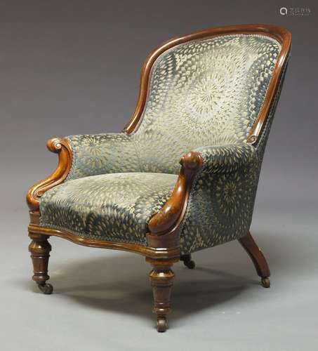 A Victorian mahogany framed armchair, with curved back, above scrolling arms, upholstered in green