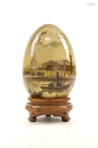 A Russian wood painted souvenir egg, decorated with a scene of a steam boat in front of a