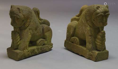 A pair of stylised carved stone lions, 20th Century, raised on plinth bases, each 49cm high (2)200