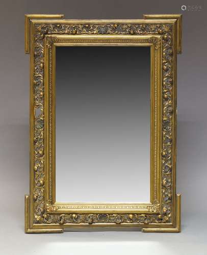 A gilt gesso wall mirror, early 20th Century, of rectangular form, with beveled plate set within a