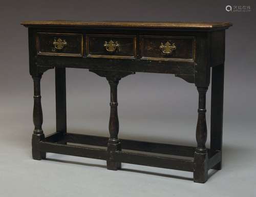 A George II style oak dresser base, 20th Century, with three frieze drawers, on front turned