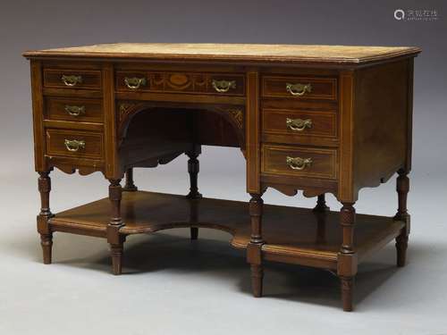 An Edwardian mahogany and inlaid kneehole desk, the rectangular top inset with tan leather writing