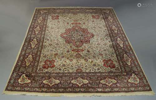 A Tabriz carpet, mid to late 20th Century, with central red medallion in an ivory foliate and floral