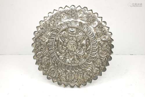 A Turkish silver circular mirror, 19th century, with shaped outline, the back embossed with a