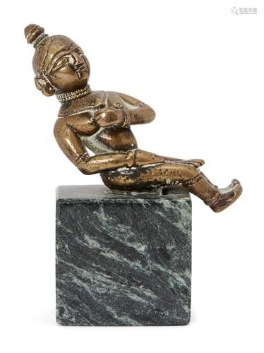 A bronze figure of a seated figure holding a flower on a marble base, India, 19th century100