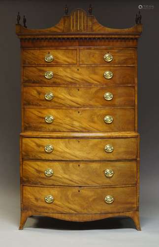 A Regency mahogany bow fronted chest on chest, the shaped cornice surmount with urn finials, above