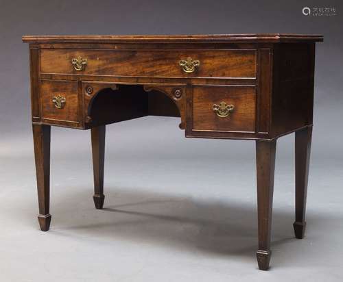 A mahogany bow front serving table, 19th Century, with one long and two short drawers, raised on