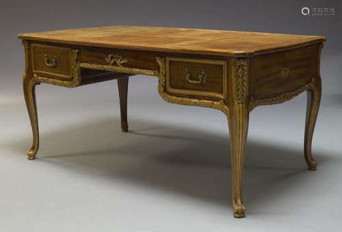 An mahogany and parcel gilt desk, early 20th Century, the rounded rectangular top inset with leather