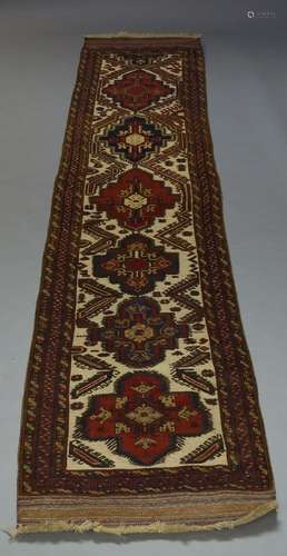 A Soumak runner, late 20th Century, with six medallions in ivory field, 390cm x 781cm, flat weave