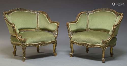 A pair of Louis XV style green upholstered bergère armchairs, first half 20th Century, each with