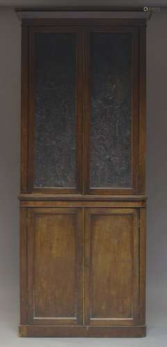 A Victorian mahogany cabinet, the moulded cornice above two leather embossed paneled doors,