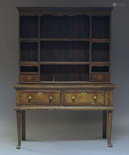 A George III oak Welsh dresser, the later plate rack with an arrangement of shelves and two drawers,