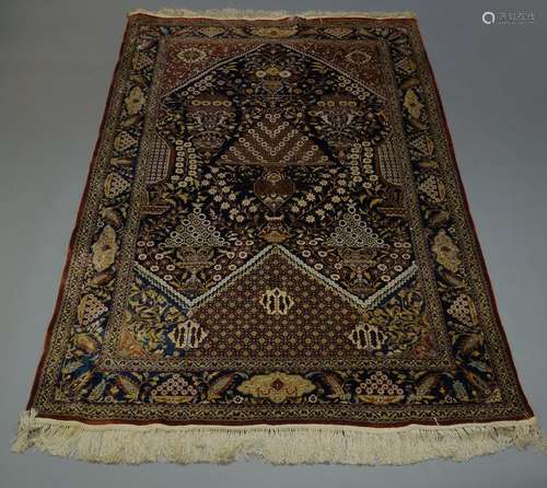 A Tehran silk rug, late 20th Century, the indigo field elaborately decorated with sprays of flowers,