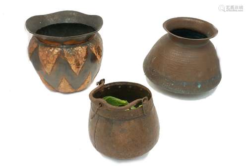 A selection of three 20th century hand beaten copper bowls of bulbous form with flared lip, the