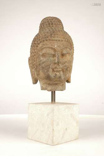 A Song dynasty style carved stone head of Buddha, 20th century, mounted on a square stone block, the