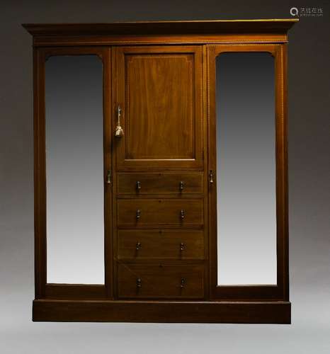 An Edwardian mahogany and inlaid triple wardrobe, the moulded cornice above cupboard door and four