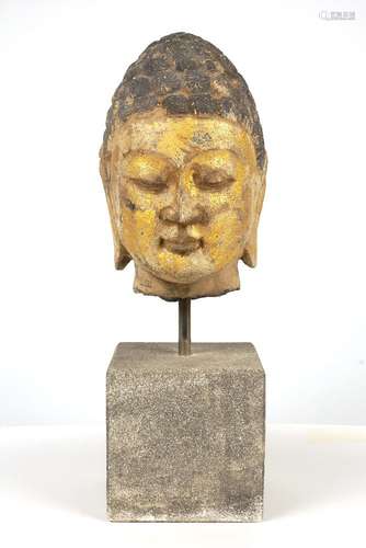 A Tang style carved and parcel gilt head of Buddha, 20th century, modelled with stylised hair and