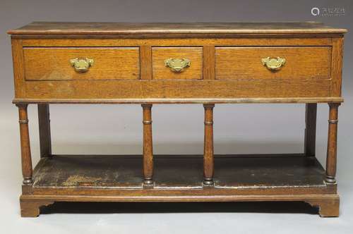 A George III oak dresser base, the rectangular plank top above one short and two long frieze