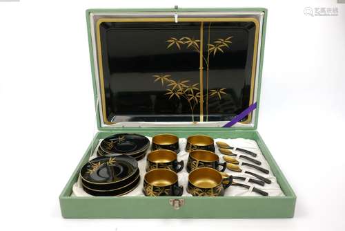 A Japanese lacquer tea set, 20th century, with black lacquer and gilt decoration in the form of