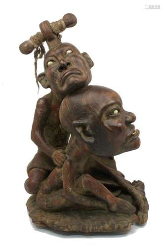 A South East Asian hardwood figure group of two men, 20th century, carved as two caricatures with