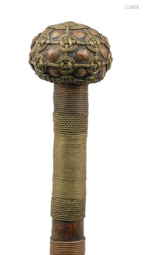 A tribal ceremonial hardwood staff, 20th century, applied with bands of brass and copper wire