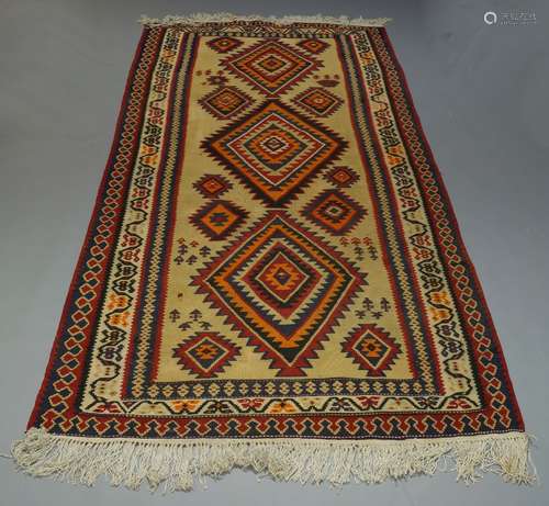 An Anatolian Kilim with three main lozenge medallions in straw coloured field, 315cm x 157cm,