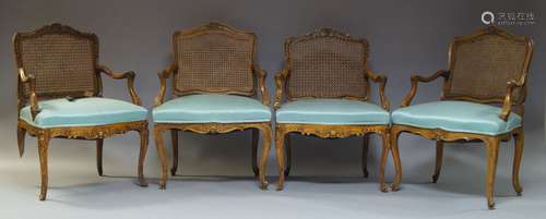 Four Louis XV style beech and caned fauteuils, 20th Century, the shaped backrest with floral