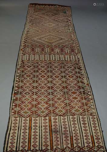 A Caucasian woven wool work runner, with polychrome lozenge design, 550cm x 118cm, together with a