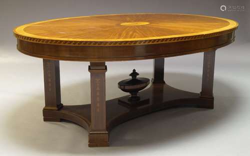 A mahogany and inlaid extending dining table, 20th Century, the oval top centred by inlaid patera,