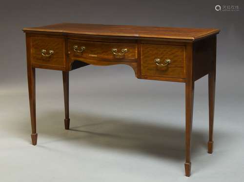 An Edwardian mahogany and crossbanded side table, the shaped top above three frieze drawers,