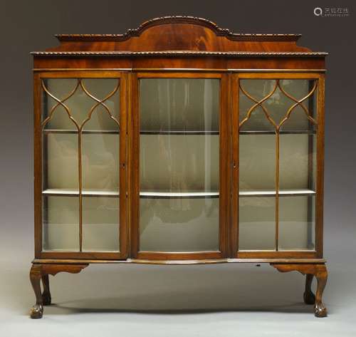 An Edwardian mahogany triple display cabinet, the top with raised shaped back, above central