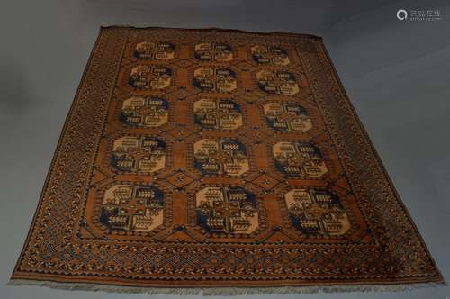 A Turkmen carpet, late 20th Century, with three rows of octagons in a deep brown field, 303cm x