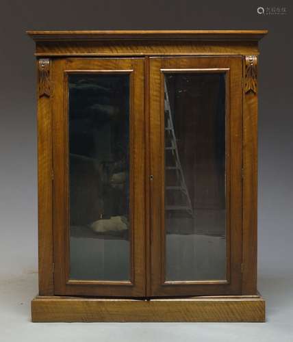 A Victorian mahogany bookcase cabinet, the moulded cornice above two glazed doors enclosing three