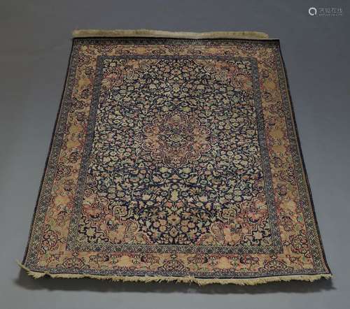 A Tabriz silk rug, early 20th Century, with pole medallion, in blue floral and foliate field,