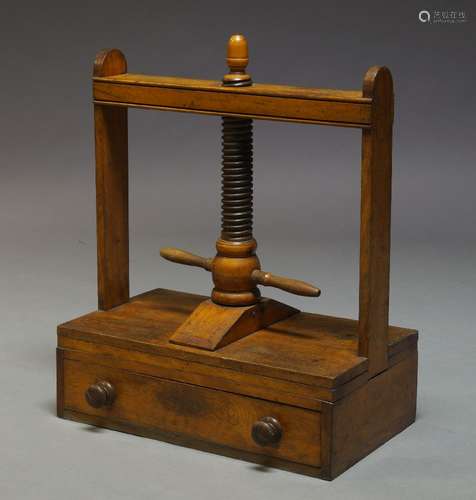 A Victorian mahogany book press, with acorn finial above a turned screw mechanism, over single