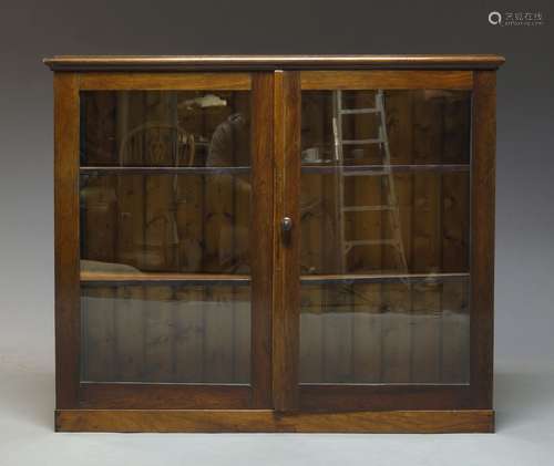 A rosewood and glazed bookcase, late 19th Century and later, the moulded top above two glazed doors,