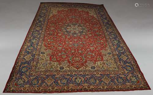 A Tabriz carpet, mid 20th Century, the pole medallion in red floral foliate field with ivory