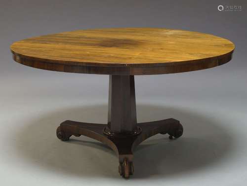 A Regency rosewood tilt top dining table, the circular top, on tapering octagonal column support, to