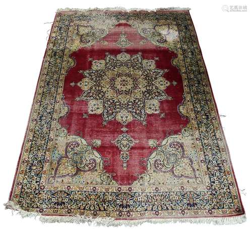 A Tabriz silk rug, mid/late 20th Century, with floral pattern pole medallion in a deep red field