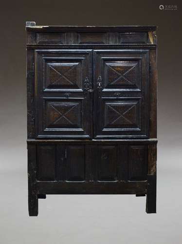 An oak court cupboard, 17th century and later, with two moulded panel cupboard doors, enclosing