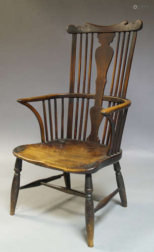 An elm and beech Windsor armchair, second half 19th Century, with shaped crest rail, above shaped