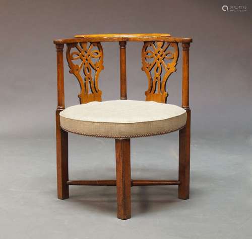 A George III fruitwood corner chair, the curved top rail over pierced splats, flanked by column